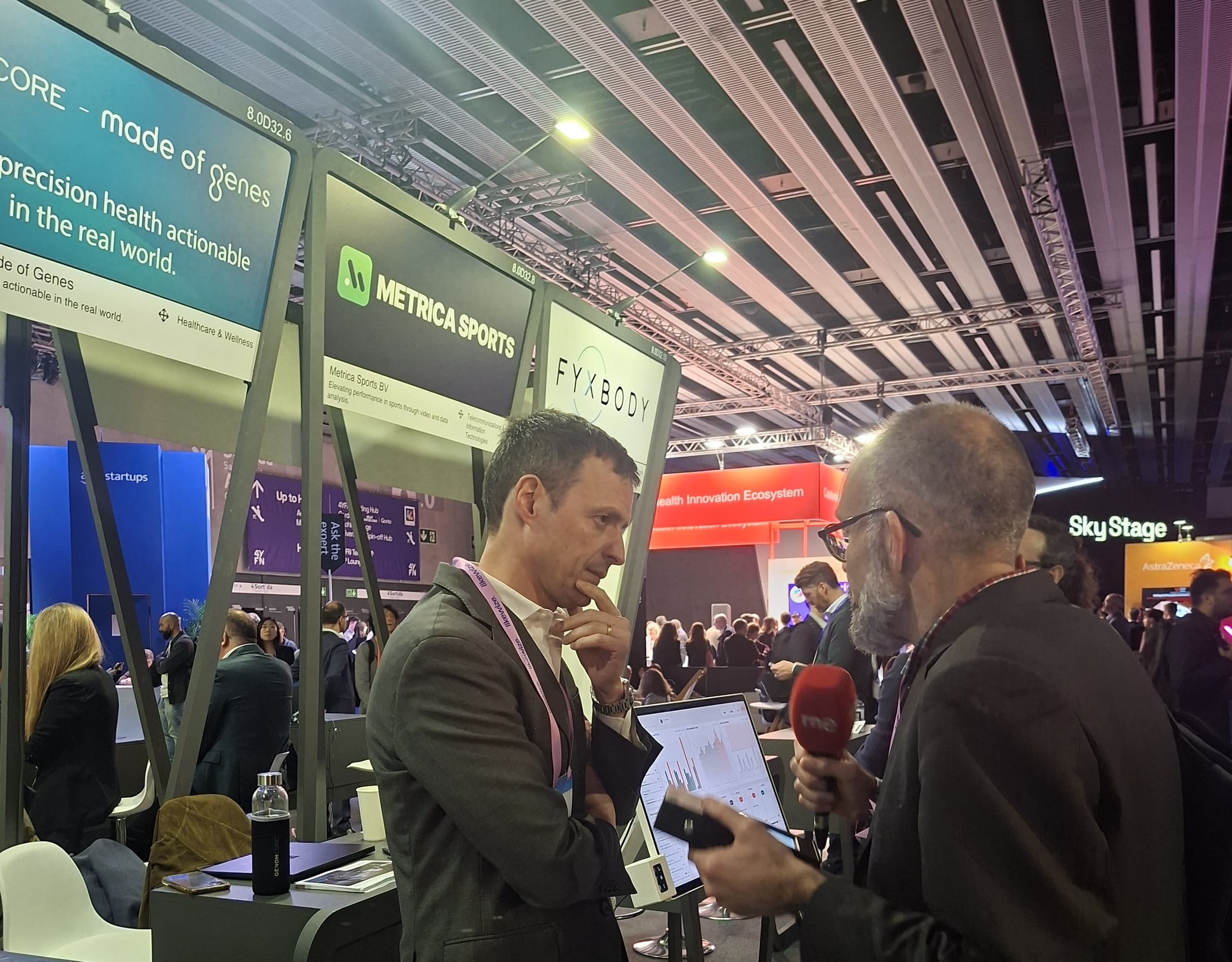 Miquel A. Bru being interviewed by Manu Martínez from RNE at the Genomcore booth during Mobile World Congress 2026
